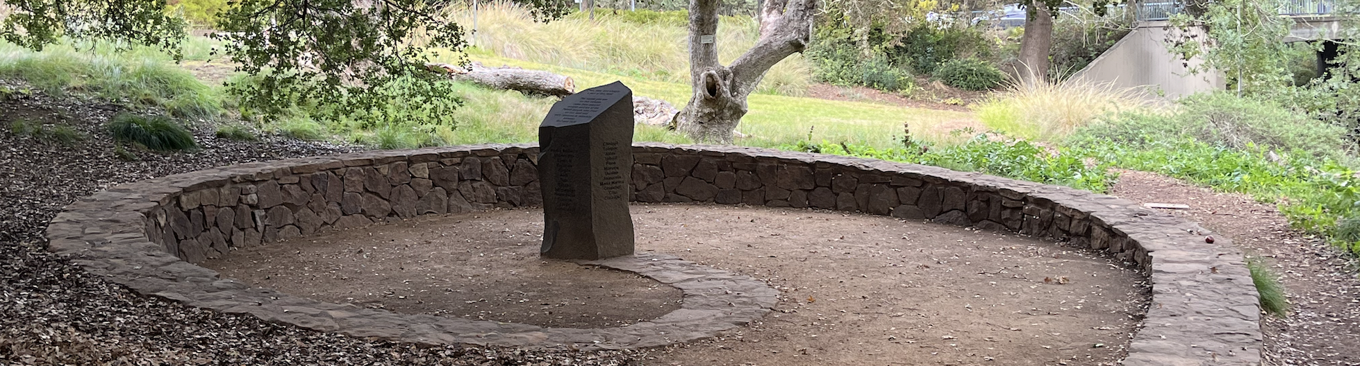 UC Davis Native American Contemplative Garden, a stone pillar in the center of a low spiral-shaped stone wall