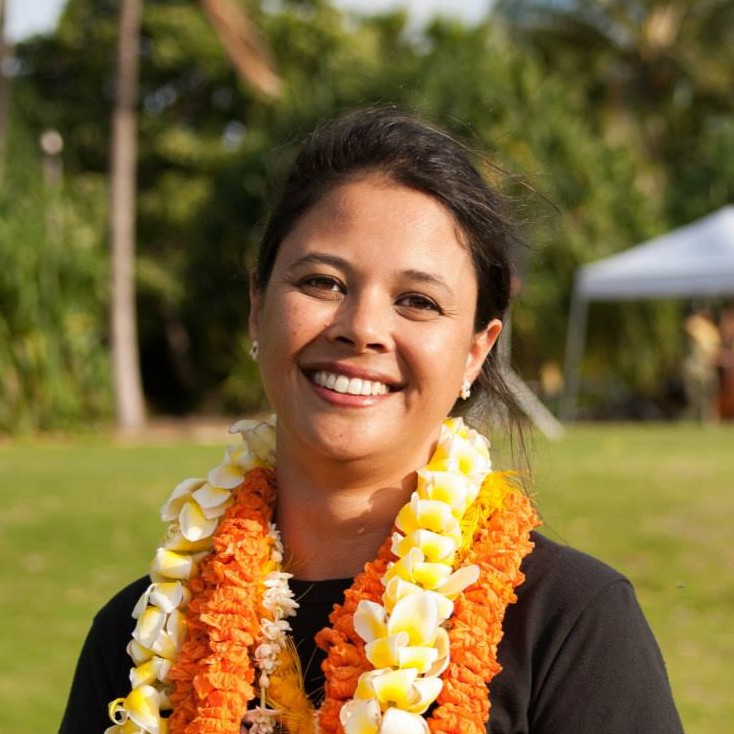 Miki‘ala Lidstone in the sunshine smiling at the camera wearing a colorful lei