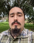 Chimaway Lopez in a checked shirt looks at the camera